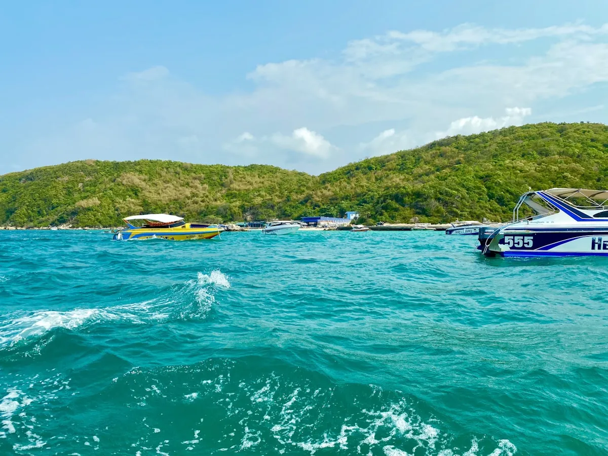 White and blue boat cruising on tropical sea