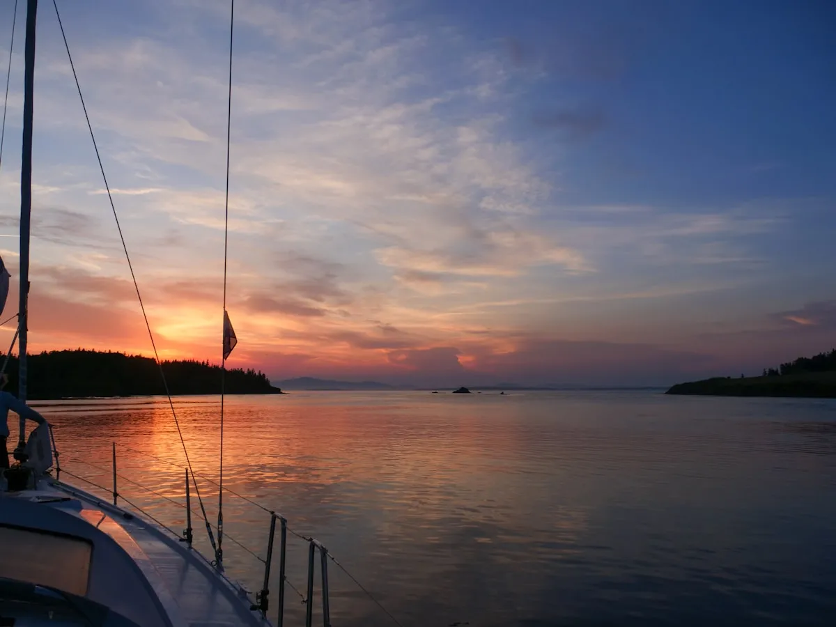 Sailboat anchored in a calm bay at sunset